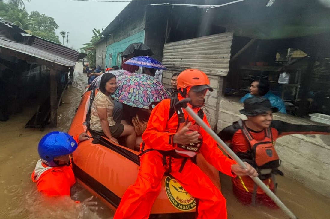 Rescuers on a rubber boat evacuate residents from their flooded home in North Sumatra province, Indonesia. (BASARNAS/AP)