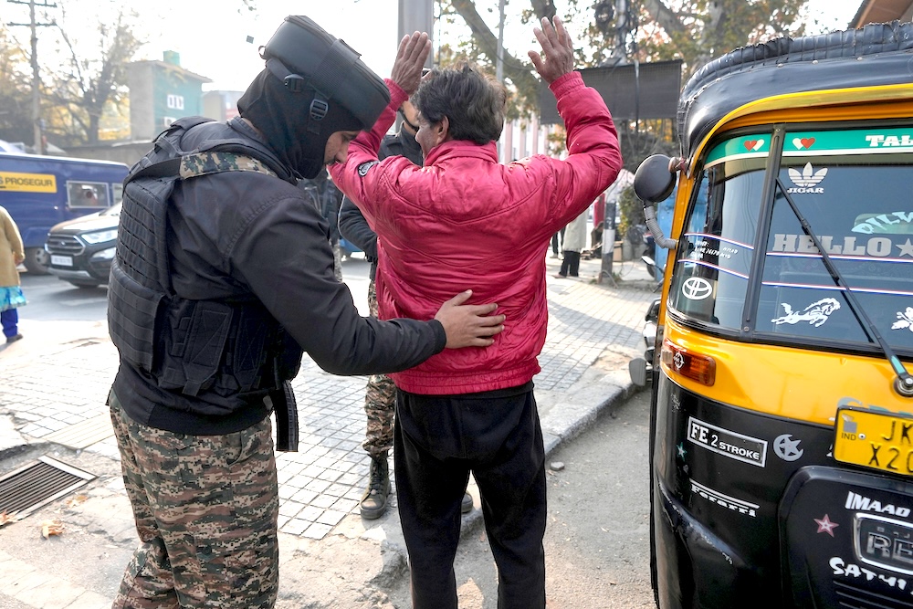 An Indian paramilitary soldier body frisks a civilian during a security check in Srinagar, Indian-controlled Kashmir on Nov. 25, 2025. (AP)
