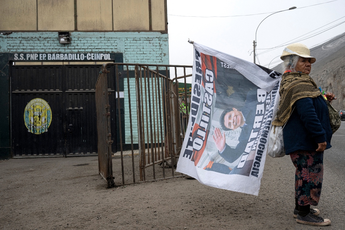 A women holds a flag in support to Peru's former President Pedro Castillo outside the Barbadillo prison in Lima, Peru. (AFP)