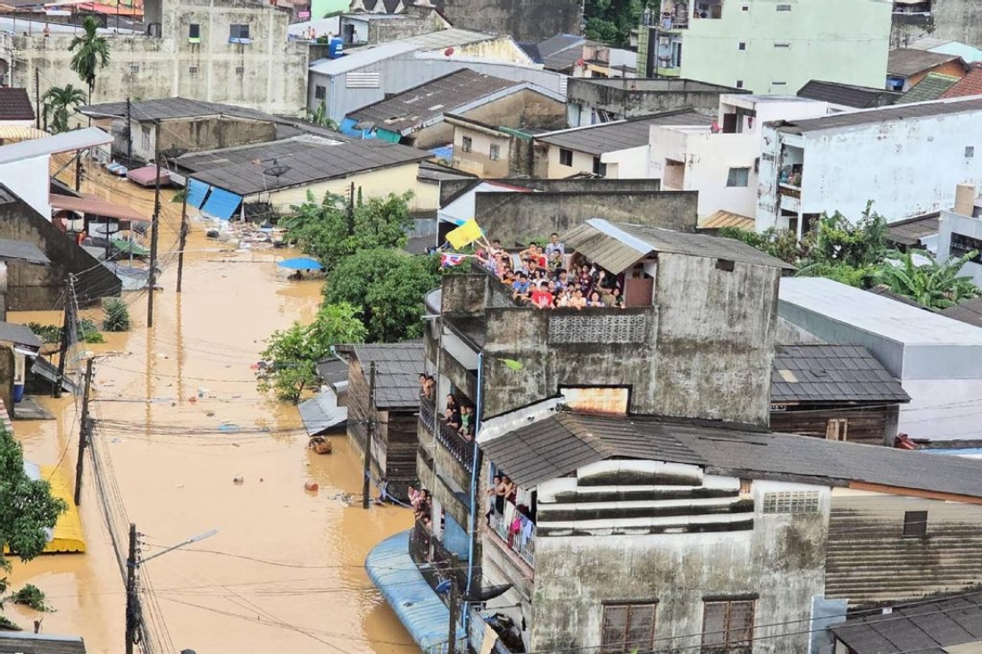 A photo people looking out from residential buildings surrounded by flood waters in Hat Yai. (AFP)