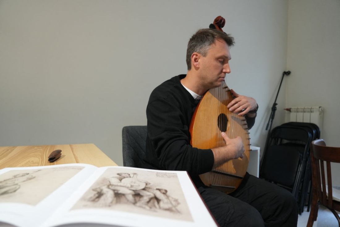 Oleksandr Savchuk, the 41-year-old owner of a small publishing house in Kharkiv, plays the bandura in Kharkiv, Ukraine. (AFP)