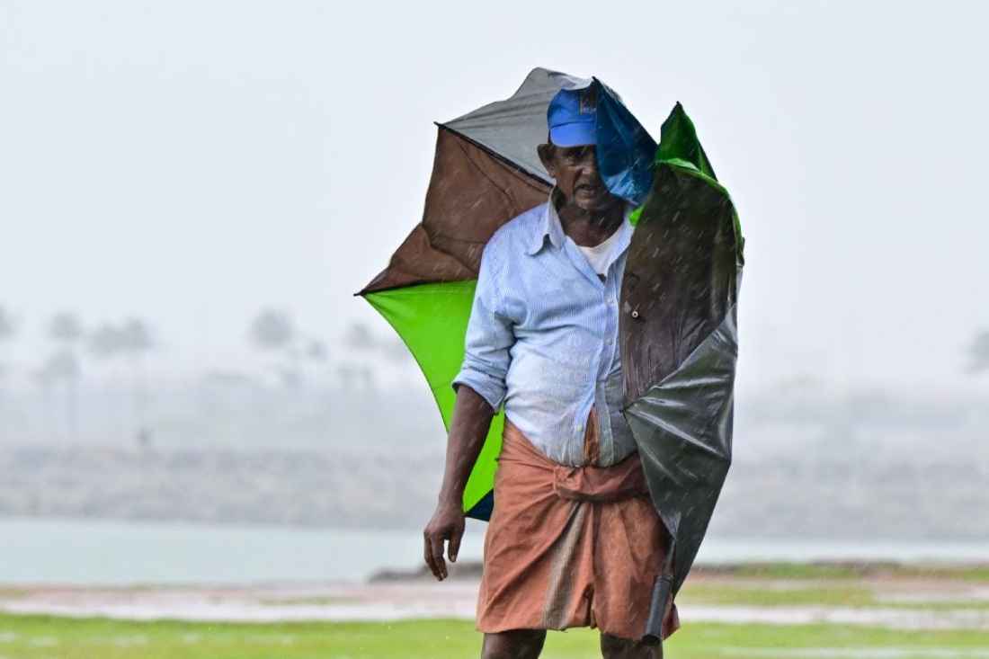 A man carries an umbrella amid rainfall in Colombo, Sri Lanka. (AFP)