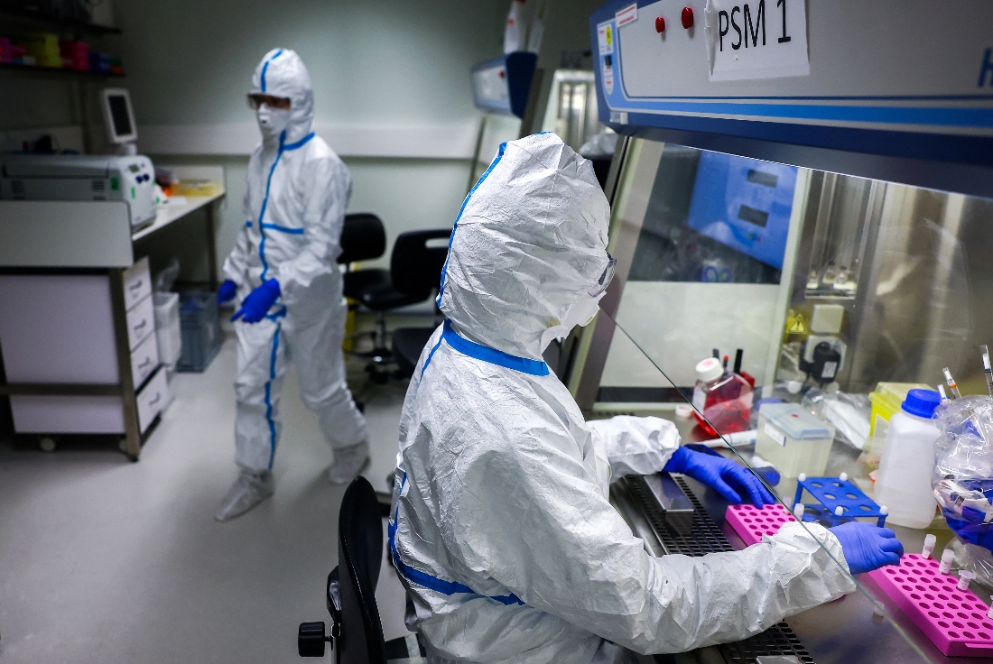 Researchers wearing protective suit work during a press visit at the Institut Pasteur in Paris, France. (Reuters)