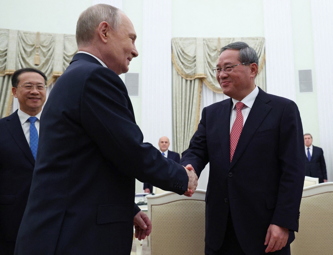 Russian President Vladimir Putin shakes hands with Chinese Premier Li Qiang during a meeting at the Kremlin in Moscow. (AFP)