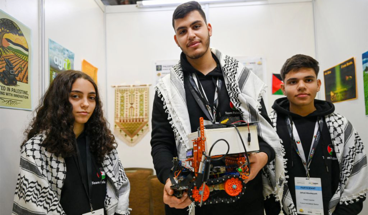 Palestinian participants Razan Shawar, Jehad Abudayyah, and Mustafa Assi pose with their robot design at the World Robot Olympiad in Singapore. (AFP)