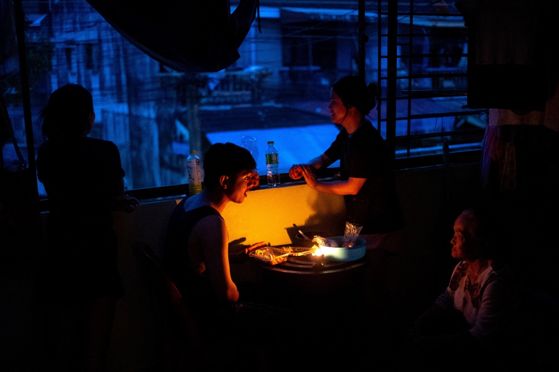 Thai family have dinner by candlelight on the balcony of a flooded house, following power outages caused by deadly flooding in Hat Yai district, Songkhla province, Thailand. (Reuters)