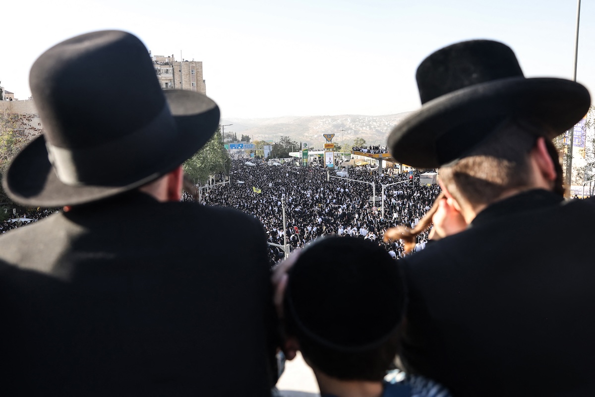 Above, bystanders look at the crowd during protest by ultra-Orthodox Jews against conscription into Israel’s military in Jerusalem on Oct. 30, 2025. (AFP)