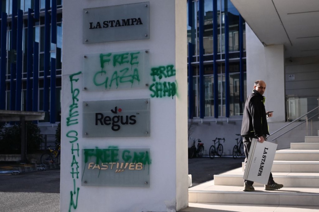 A man holds a placard of Italian newspaper La Stampa outside the editorial offices of newspapers La Stampa and Repubblica in Turin, Italy. (AFP)