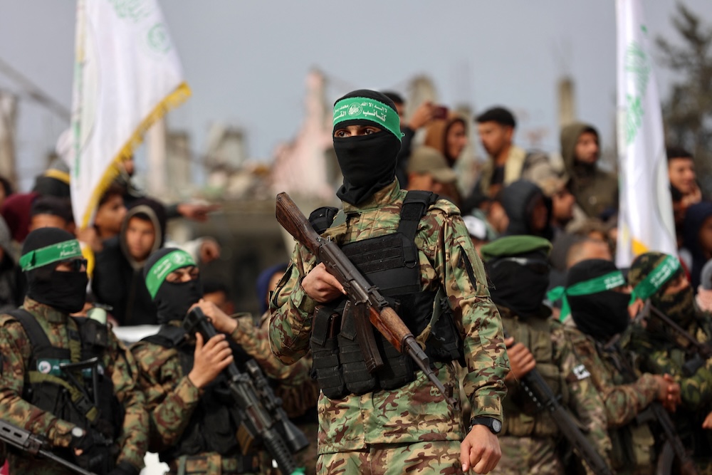 Above, Hamas fighters gather at the site of the handing over of two Israeli hostages in Rafah in the southern Gaza Strip on Feb. 22, 2025. (AFP file photo)