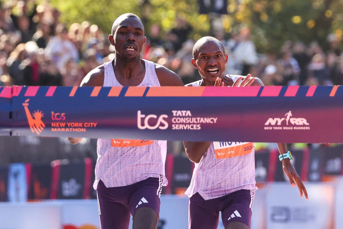 Kenyans Benson Kipruto (L) and Alexander Mutiso celebrate taking first and second place respectively as they reach the finish line in the New York Marathon in New York on Sunday. (AFP)