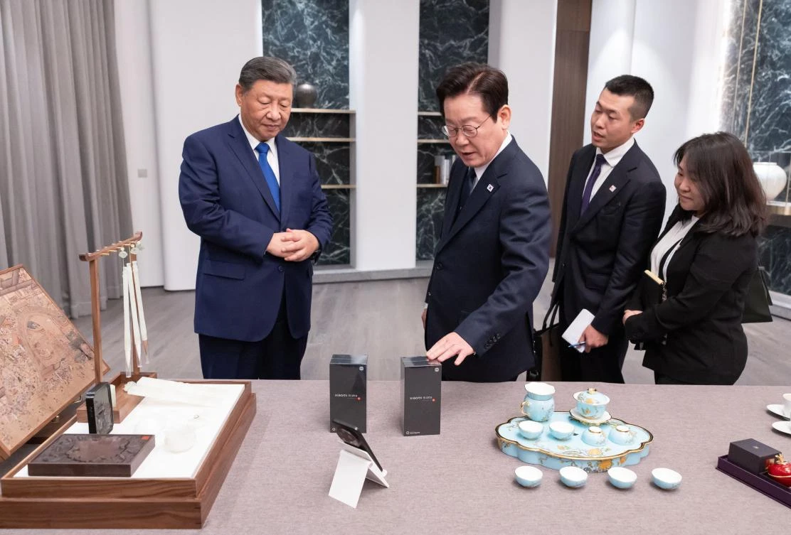 South Korea’s President Lee Jae Myung, second left, and China’s President Xi Jinping, left, exchange gifts during a meeting on the sidelines of the Asia-Pacific Economic Cooperation in Gyeongju on Nov. 1, 2025. (South Korean Presidential Office via Yonhap/AFP)