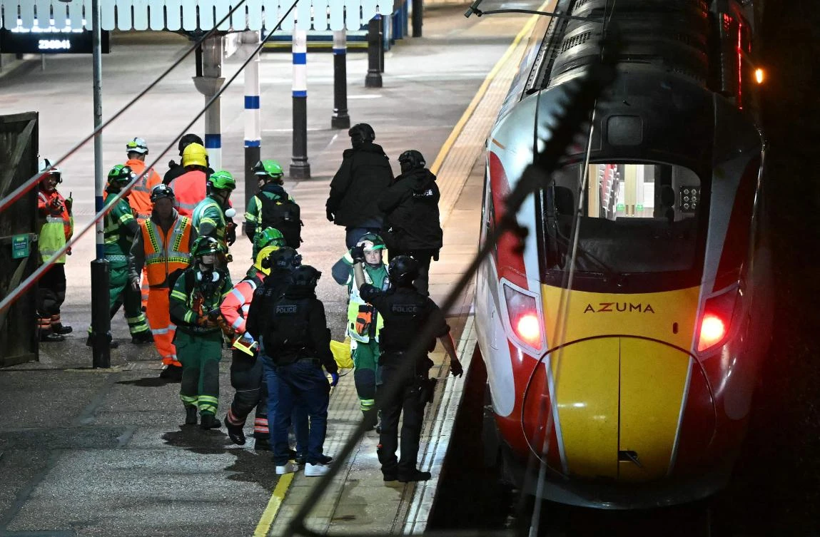 Above, police officers and emergency services workers alongside an LNER Azuma train at Huntingdon Station in Huntingdon, eastern England on Nov. 1, 2025. (AFP)