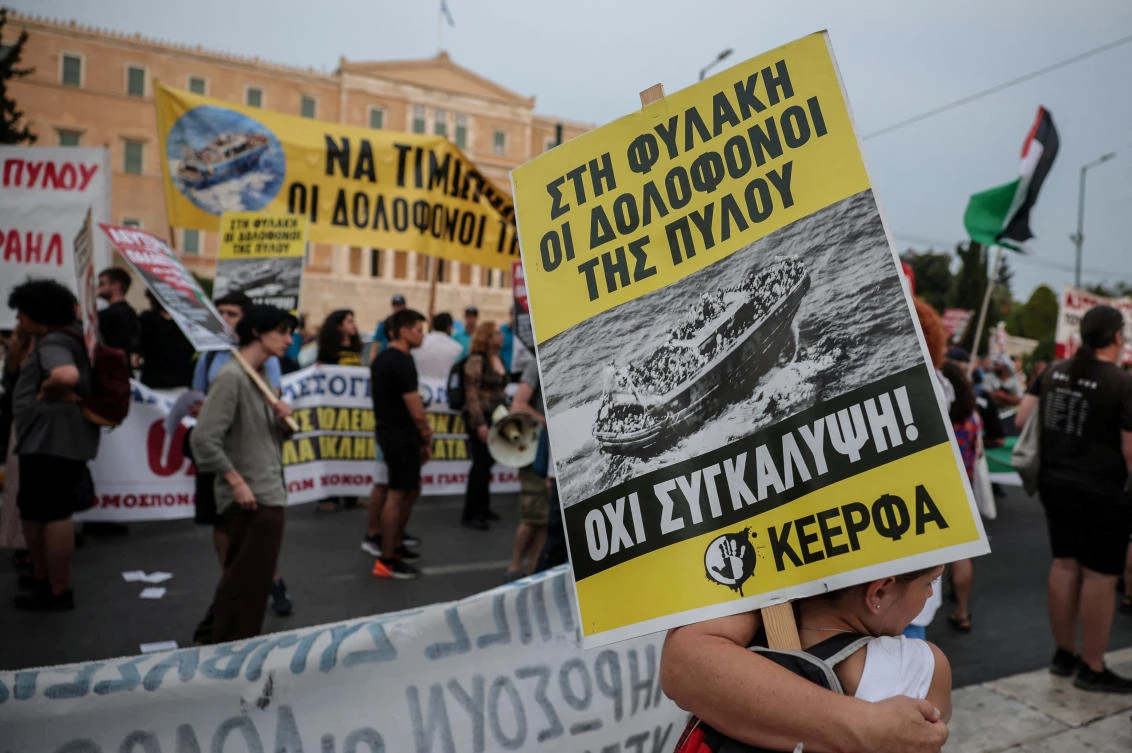 A protester carries a placard reading “no to cover-up” as activists, survivors and other protesters gather to mark the second anniversary of one of the Mediterranean’s worst shipwrecks in 2023 off Greece’s southwestern town of Pylos, in Athens, Jun. 21, 2025. (Reuters/File)