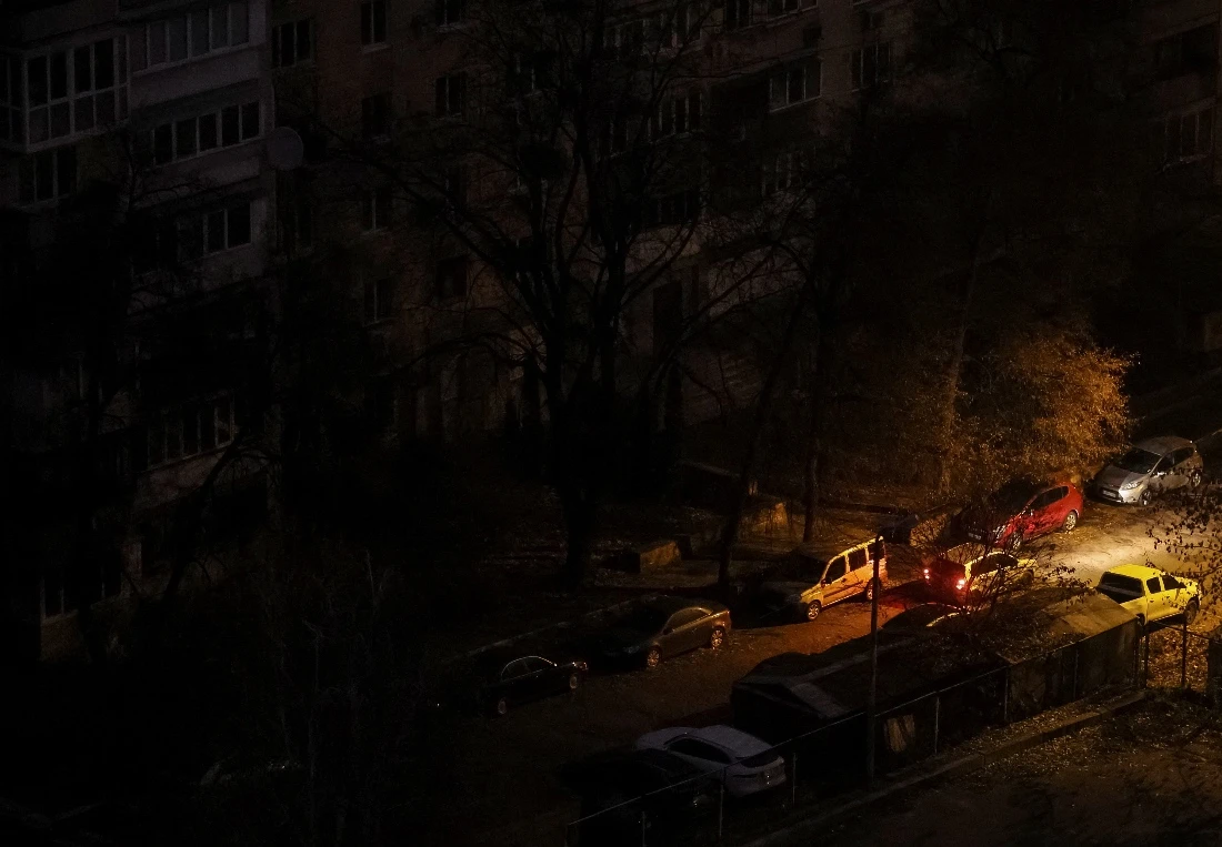 A car passes next to residential buildings during a power blackout after critical civil infrastructure was hit by Russian missile and drone attacks, amid Russia's attack on Ukraine, in Kyiv, Ukraine. (Reuters)