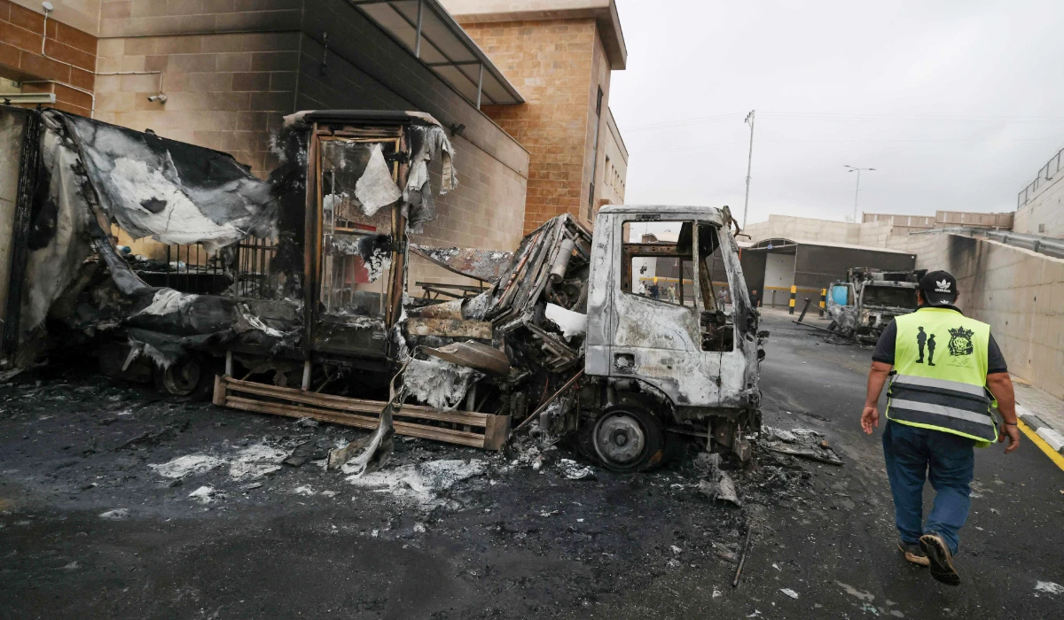 A Palestinian man inspects a burnt truck after an Israeli settlers attack in the village of Beit Lid, east of Tulkarm in the occupied West Bank on November 11, 2025. (AFP)