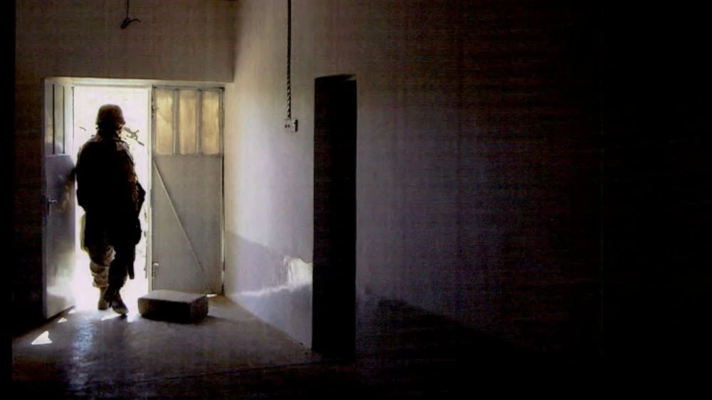 A US marine walks out of a home in Haditha, Iraq, after multiple civilians were killed in November 2005. (NCIS)