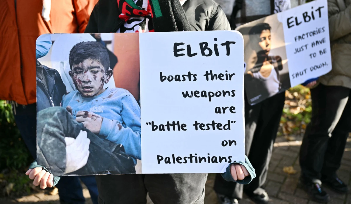 Supporters of alleged Palestine Action activists accused of breaking into Israeli-based defence firm Elbit Systems' site in Bristol in August 2024, hold placards outside Woolwich Crown Court in south east London on November 17, 2025, where the activists are due to stand trial. (AFP)