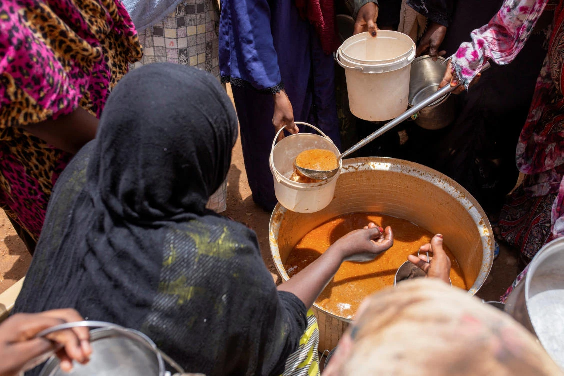 Above, Sudanese women from community kitchens distribute meals for people who are affected by conflict and extreme hunger in Omdurman, Sudan on July 27, 2024. (Reuters)
