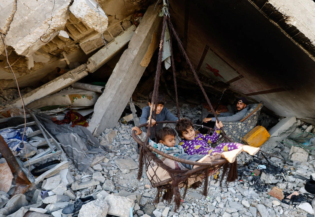 Palestinian children play with a swing among the ruins of a building, amid a ceasefire between Israel and Hamas, in the northern Gaza Strip, on November 19, 2025. (REUTERS)