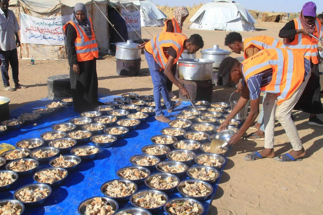 Sudanese volunteers prepare free meals for those who fled El-Fasher at the Al-Afad camp for displaced people in the town of Al-Dabba, northern Sudan, on November 20, 2025. (AFP)