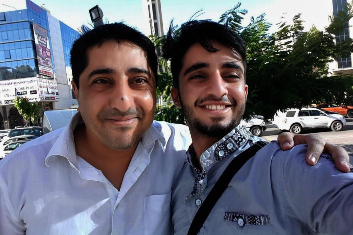 In this July 11, 2016, photo provided by Khaled al-Yemeni, Ahmed al-Yamani, left, smiles for a photo with his son, Khaled al-Yemeni. (Khaled al-Yemeni via AP)