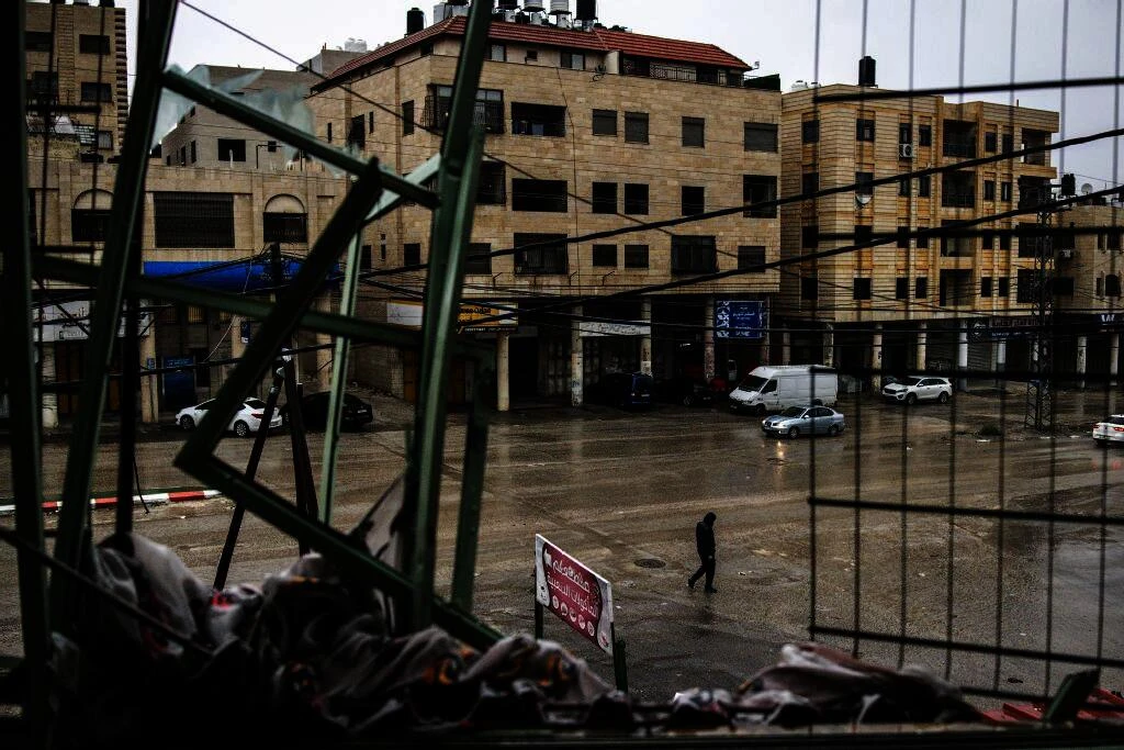 A man walks on the street below, past a destroyed apartment the morning after an Israeli military operation in which one Palestinian gun man was killed, in the Israeli-occupied northern West Bank city of Nablus, on November 25, 2025. (AFP)