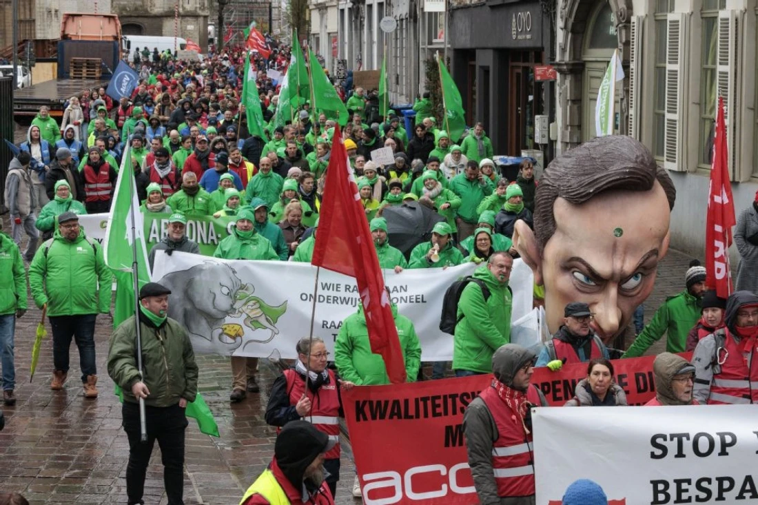 Demonstrators carry an effigy depicting Belgium's Prime Minister Bart De Wever pictured as they march along a street to denounce the consequences of federal government measures during the second day of a 72 hours national strike, in Gent, Belgium. (AFP)