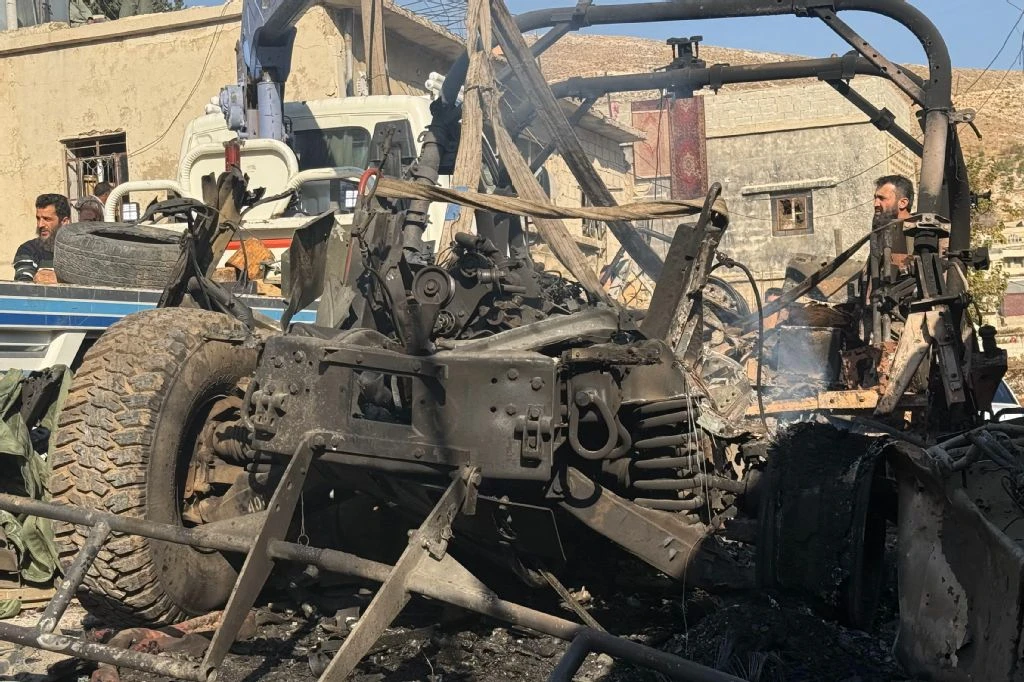 A crane removes a burnt Israeli Humvee from a street in the southern Syrian village of Beit Jin on November 28, 2025. (AFP)