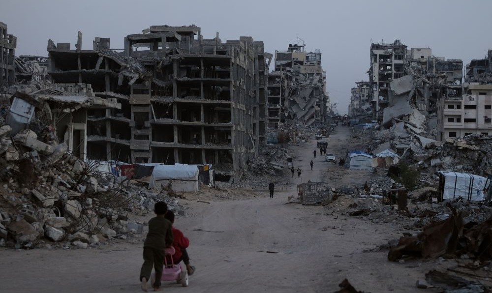Palestinians walk through Al-Karama, Gaza City, Nov. 30, 2025. (AP Photo)