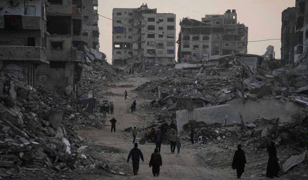 Palestinians walk through Al-Karama, Gaza City, Nov. 30, 2025. (AP Photo)