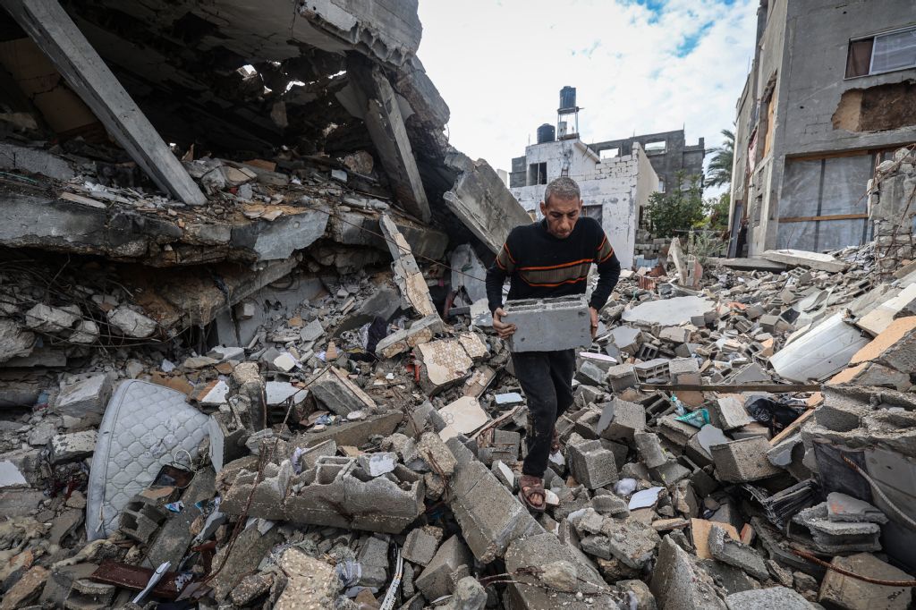 Palestinian Ahmed Al-Mabhuh collects breeze blocks salvaged from the rubble of his destroyed home to build a shelter. (AFP)