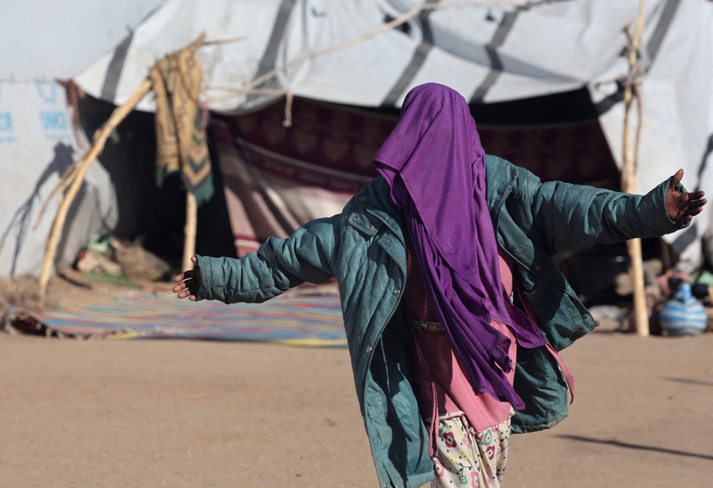 A Sudanese refugee from Al-Fashir gestures inside the Tine transit refugee camp in eastern Chad. (Reuters)