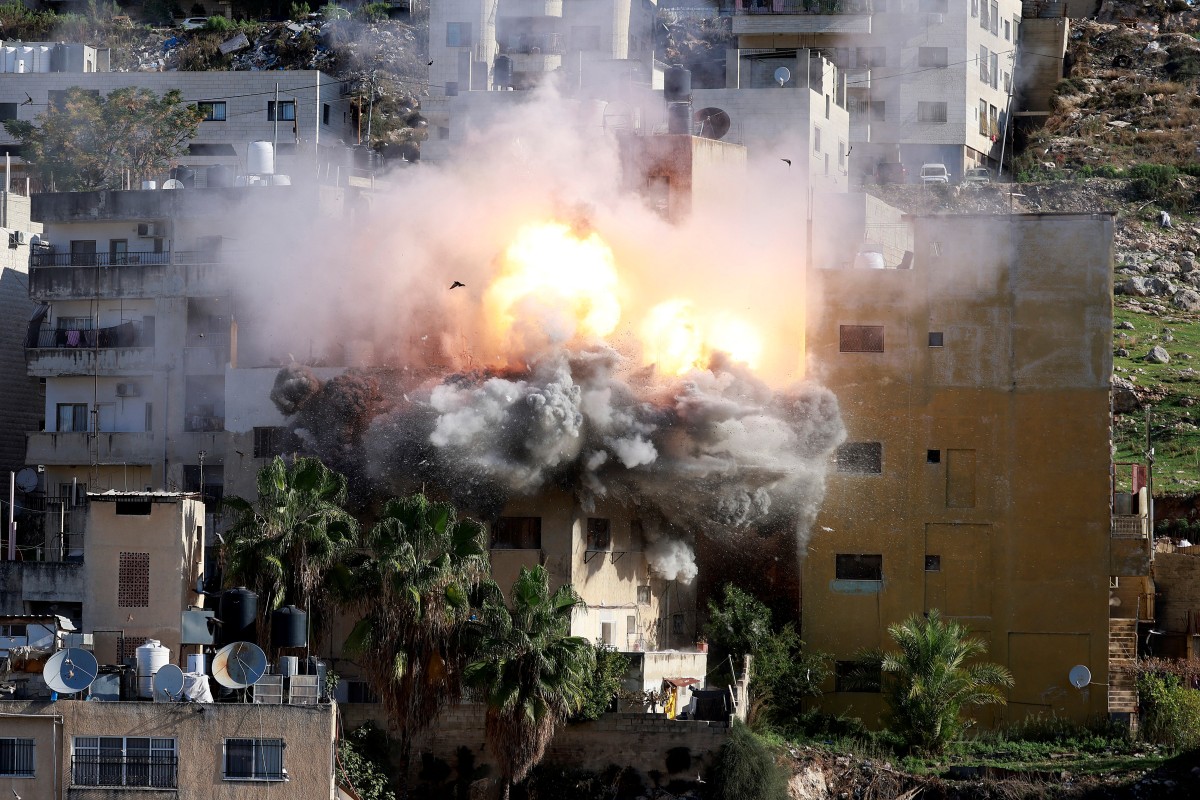 Smoke billows as Israeli forces demolish the house of Abdul Karim Sanoubar, who was detained by Israel earlier this year after being accused of plotting bus bombings, in the occupied West Bank city of Nablus. (AFP)
