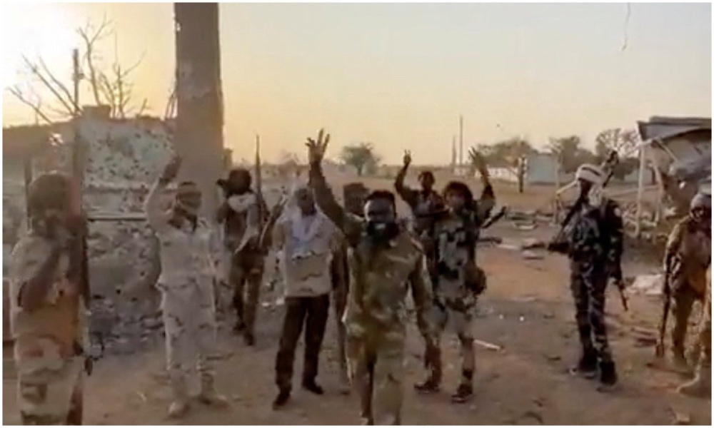 Members of Sudan’s paramilitary Rapid Support Forces (RSF) stand in front of the main gate of the 22nd SAF Infantry Division, in Babanusa, Sudan, Dec. 1, 2025. (Screengrab via Reuters)