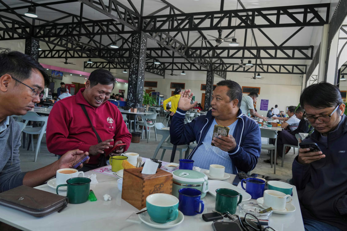 Above, residents use their mobile phones at a tea shop in Naypyitaw, Myanmar on Dec. 1, 2025. Myanmar’s military said it has arrested a man who sent anti-election messages in a private Facebook chat. (AP)