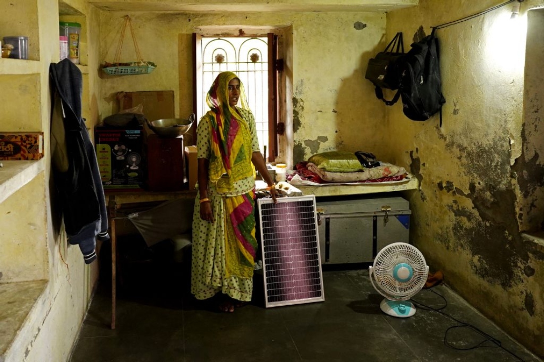 Champa Devi posing with a solar panel inside her house in Rajasthan's Beawar district, India. (AFP)