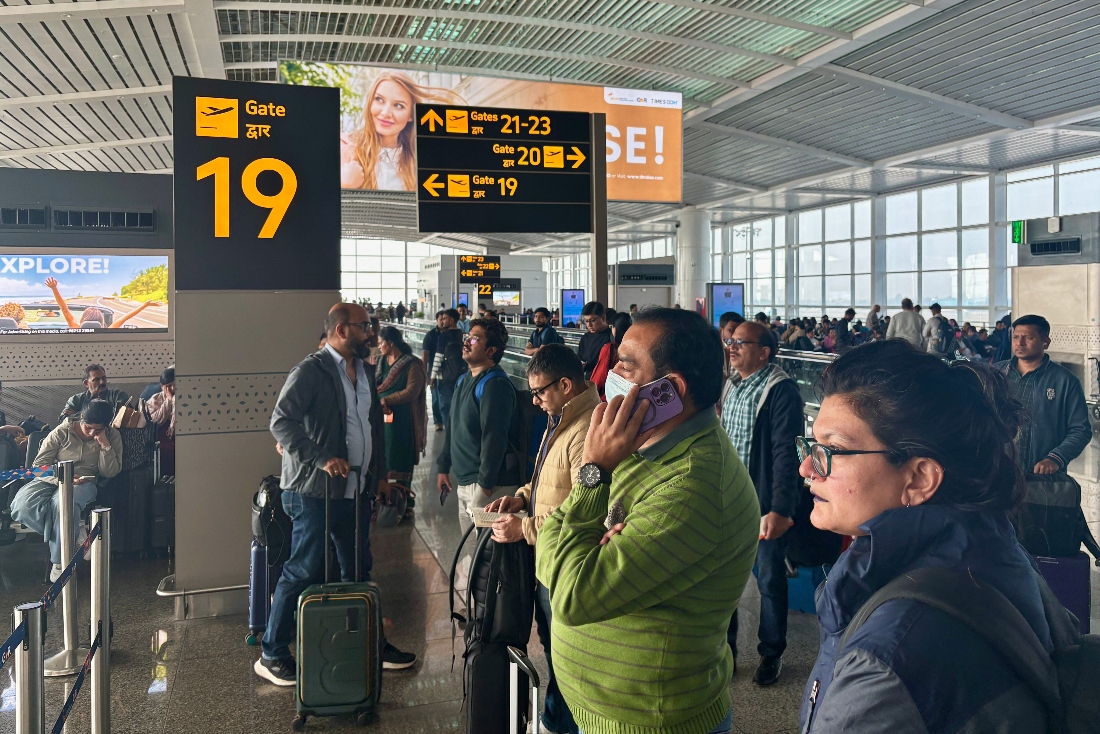 Passengers wait outside the Indira Gandhi International Airport in New Delhi, India. (AP)