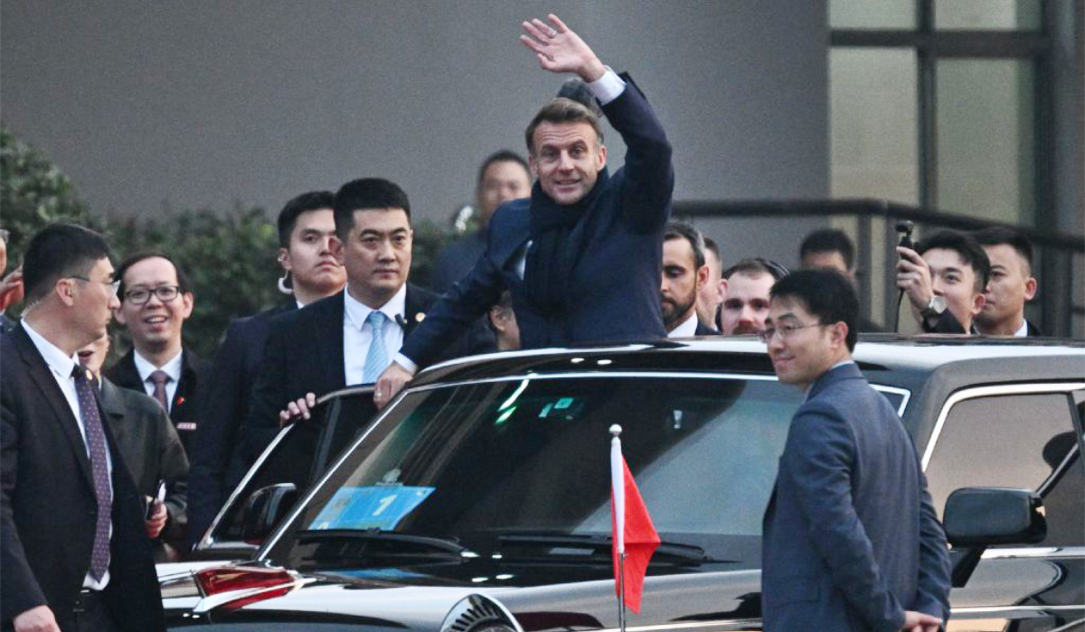 France’s President Emmanuel Macron (C? waves as he leaves the University of Sichuan after a meeting with students in Chengdu, in southwestern China's Sichuan province on December 5, 2025. (AFP)