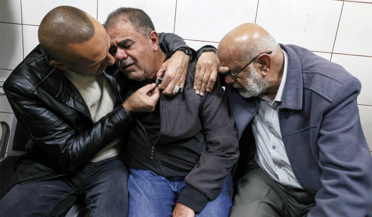 Palestinians try to console the father (C) of Bahaa Rashed at Rafidia hospital in Nablus after he was killed during an operation by Israeli forces in the village of Odala, south of Nablus in the occupied West Bank, on December 5, 2025. (AFP)
