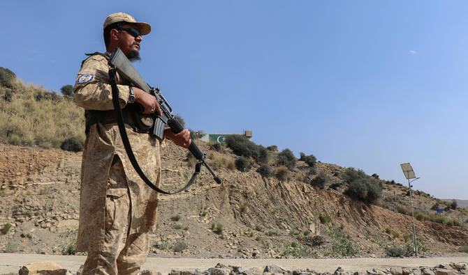 A Taliban security personnel stands guard along a road near the Ghulam Khan zero-point border crossing between Afghanistan and Pakistan in Gurbuz district in the southeast of Khost province, Afghanistan, on October 20, 2025. (AFP/File)