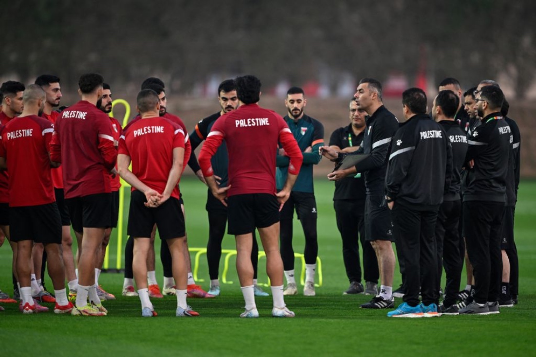 Palestine's players listen to head coach Ihab Abu Jazar during a training session ahead of their FIFA Arab Cup 2025 group stage football match against Syria, in Doha, Qatar. (AFP)