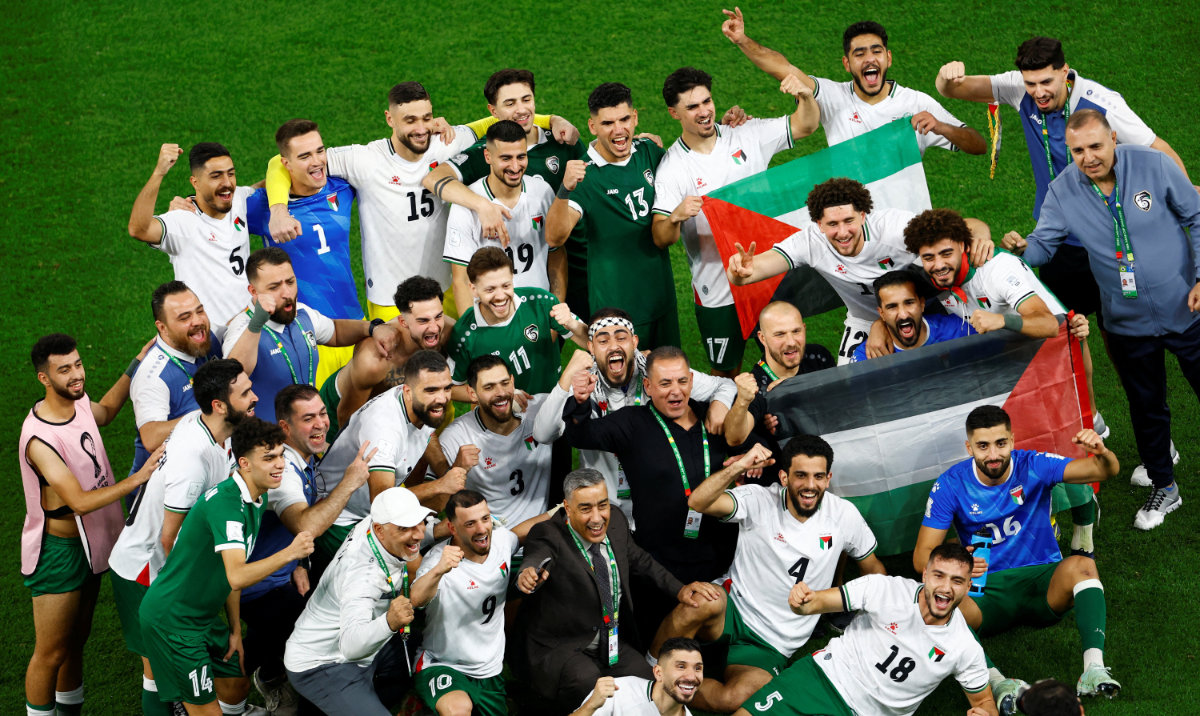Palestine and Syria players celebrate after qualifying for the FIFA Arab Cup knockout stage at the Education City Stadium in Al-Rayyan on December 7, 2025. (Reuters)