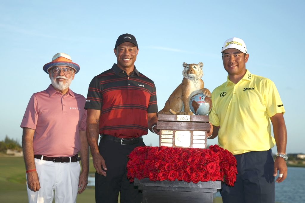 Hideki Matsuyama of Japan poses with the Hero Chairman Dr. Pawan Munjal, Tiger Woods and the trophy after putting in to win on the 18th green in a playoff after the final round of the Hero World Challenge 2025 at Albany Golf Course on Sunday in Nassau, Bahamas. (Getty Images via AFP)