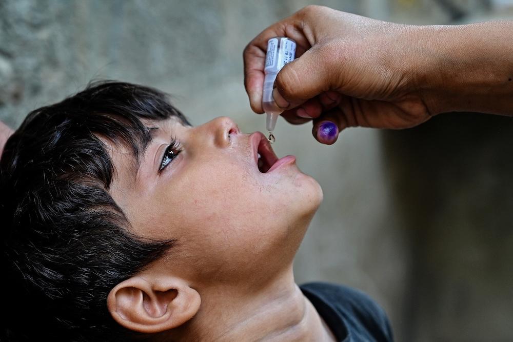 Above, a health worker administers polio drops to a child for vaccination on the first day of a nationwide week-long poliovirus eradication campaign in Karachi on Oct. 13, 2025. (AFP file photo)