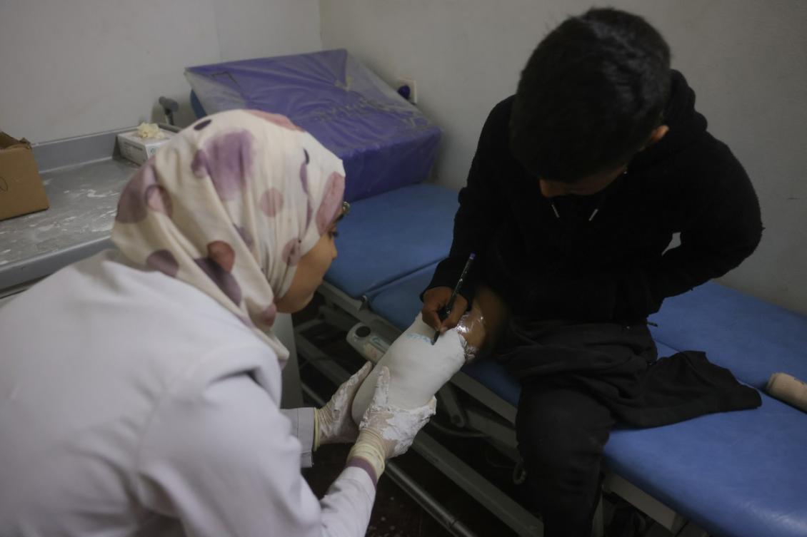 A medical personnel assists a young displaced Palestinian amputee at the Sheikh Hamad Hospital for Rehabilitation and Prosthetics in Gaza city.(File/AFP)