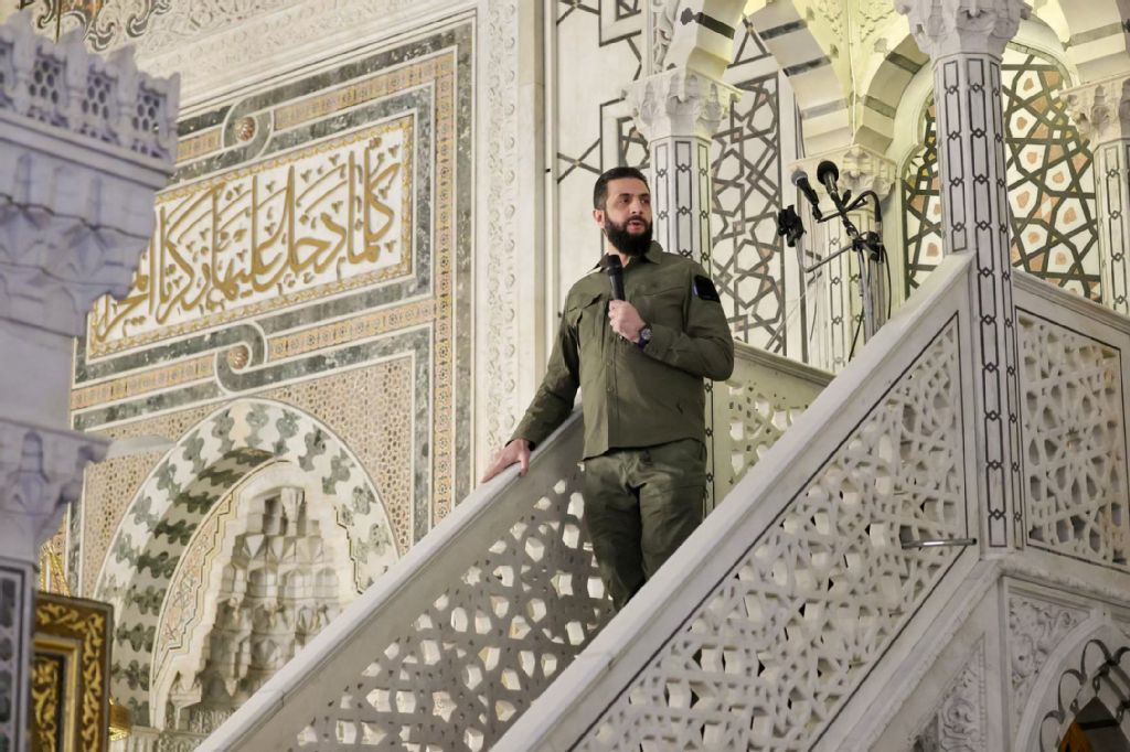 This handout photograph released by the official Syrian Arab News Agency (SANA) on December 8, 2025, shows Syrian President Ahmed Al-Sharaa speaking while attending prayers at Umayyad Mosque in Damascus during the anniversary of the ousting of longtime ruler Bashar Assad. (AFP/SANA)