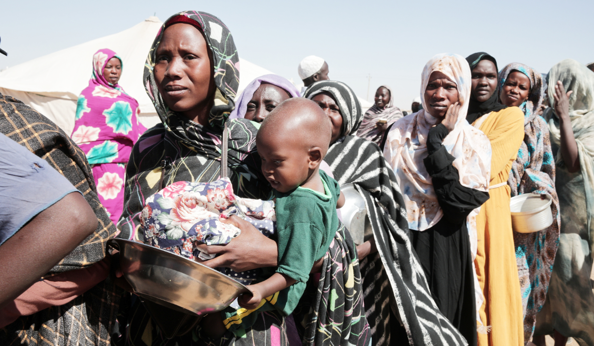 Women displaced from El-Fasher stand in line to receive food aid at the newly established El-Afadh camp in Al Dabbah, in Sudan's Northern State, Nov. 16, 2025. (AP)