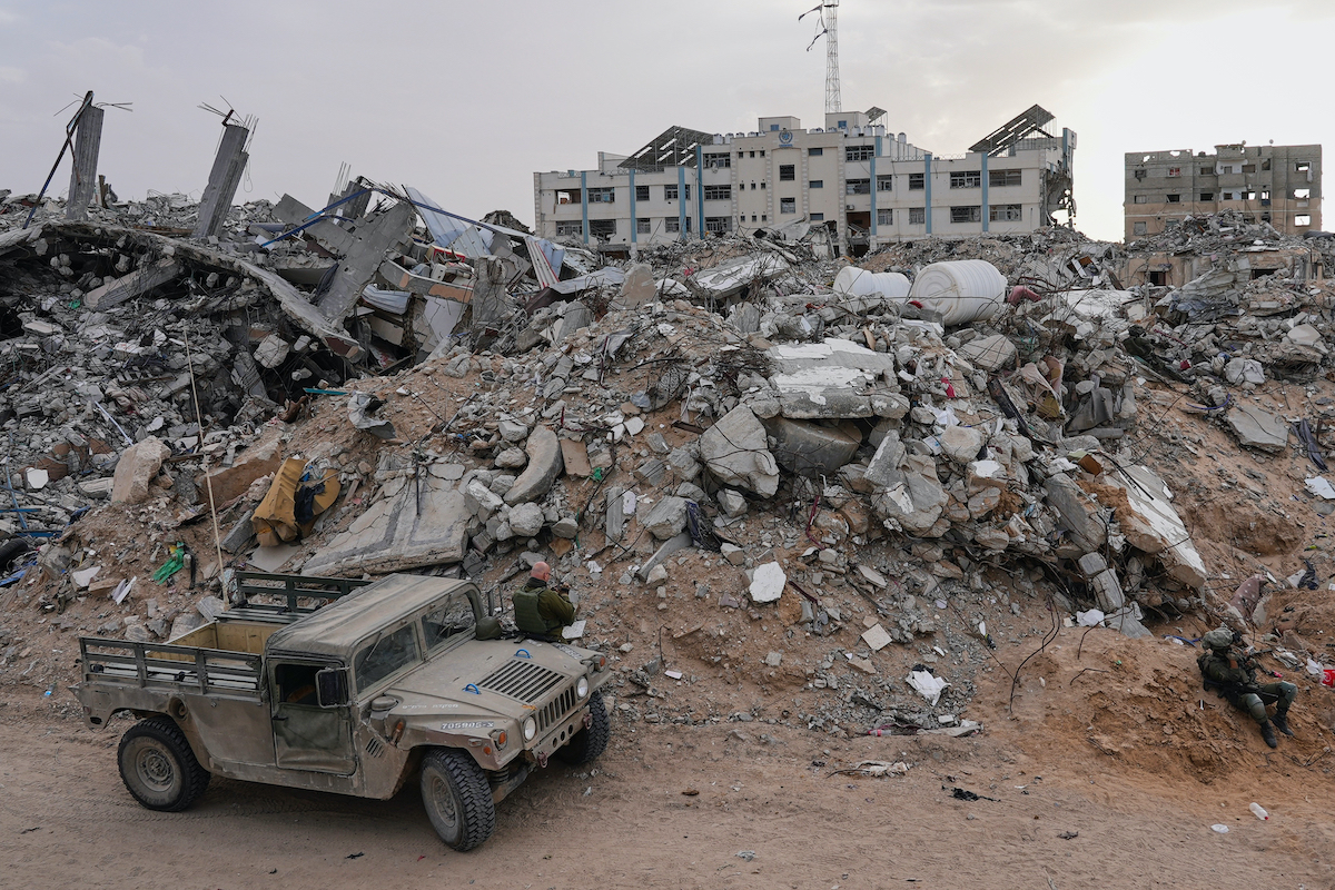 Israeli soldiers gather next to the entrance of a tunnel where the army says the body of soldier was held in Rafah, Gaza Strip on Monday. (AP)