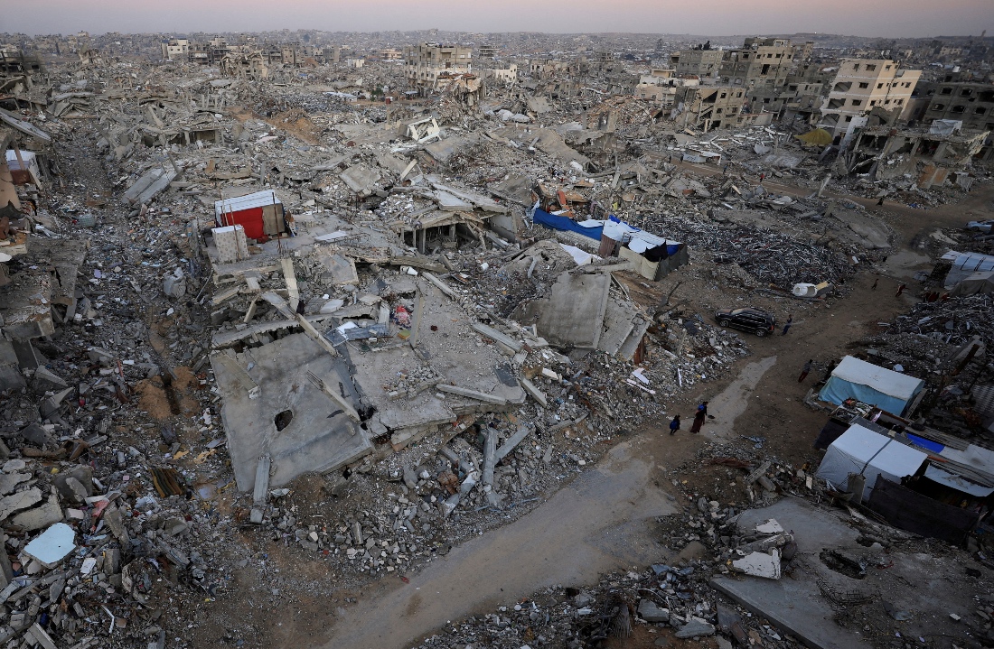 Palestinians stand near rubble from destroyed buildings, amid a ceasefire between Israel and Hamas, in Gaza City. (Reuters)