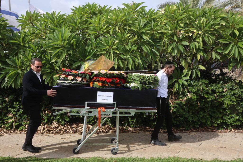 A member of a repatriation company prepare the coffin of Thai national Sudthisak Rinthalak at Ben-Gurion Airport on December 9, 2025. (AFP)